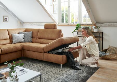 Sedací souprava DAKOTA_ sestava 2,5L -1,5KOGR_ ukázka úložného prostoru v taburetovém ukončení_ volitelná funkce za příplatek_ v látce Deluxe zimt_ foto s modelem_  obr. 7