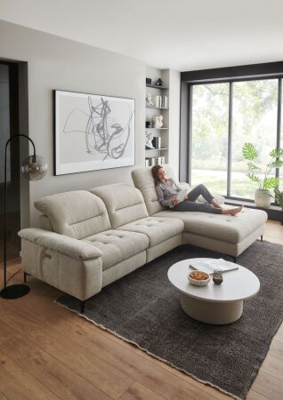 Sedací souprava CORTINA 2600_ sestava 4682_ rohové rozměry zleva 308 x 184 cm_ polohovatelné opěrky hlavy ve standardu_ ostatní volitelné funkce a polštáře za příplatek_ v látce Yelda natur_ foto s modelem_ obr. 19