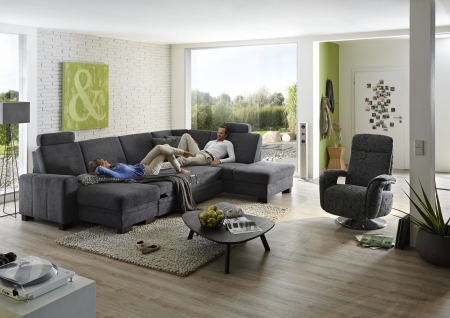 Sedací souprava CINCINATTI_ sestava CanL-2,5EL-SE-1,5AhoR_ rohové rozměry zleva 163 x 319 x 241 cm_ volitelné funkce a polštáře za příplatek_ v látce Miro grau_ foto s modelem_ relaxační  křeslo INTRO není součástí sestavy (možno objednat separátně)_ obr. 7